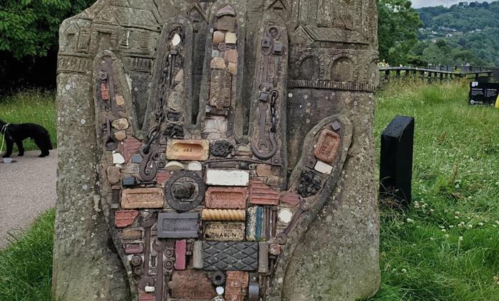 The hand sculpture embedded in to rock made from bricks and other objects